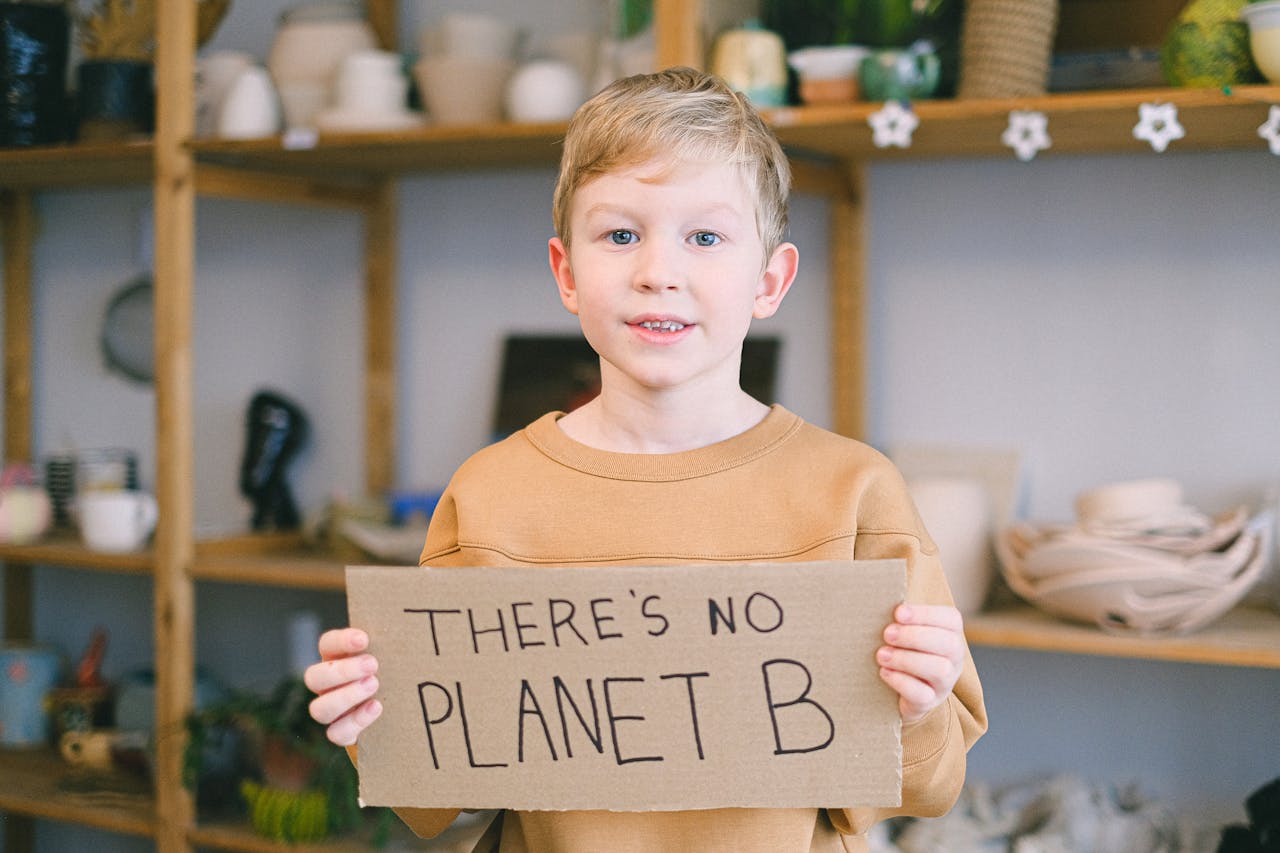 A Young Boy in Brown Sweater Holding a Placard